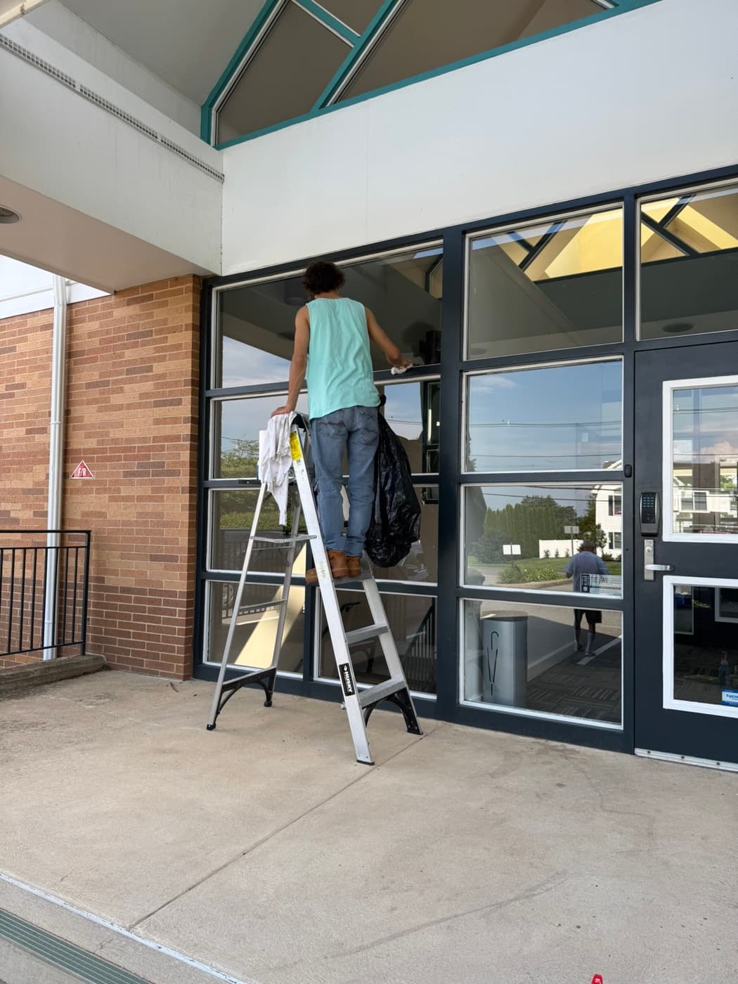 Washing the glass at a commercial entrance, Alpha. Patriotic Office Cleaning.